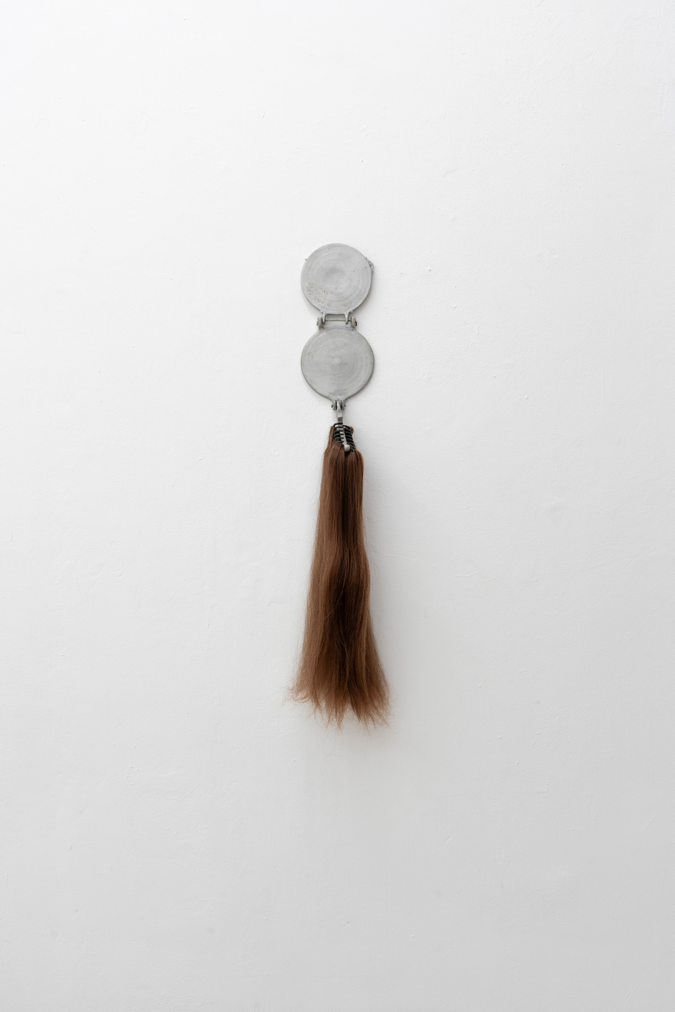 Luis Javier Murillo Zúñiga, Mi Hermana La Tortillera, stainless aluminium tortilla press with gorgeous hair extensions, exhibition view LA TERRE': My Likeness in Relics at Bistro 21, © photo by Laura Wichmann, 2024