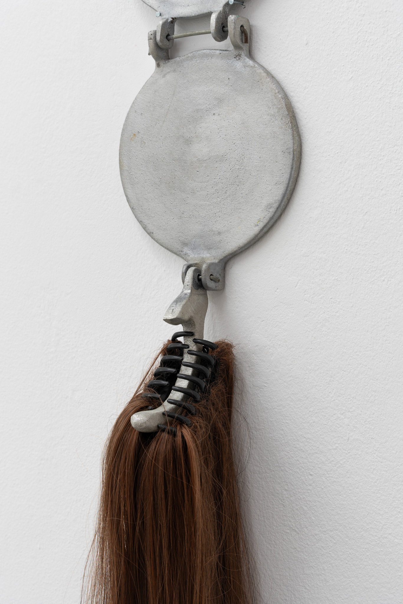 Luis Javier Murillo Zúñiga, Mi Hermana La Tortillera, stainless aluminium tortilla press with gorgeous hair extensions, exhibition view LA TERRE': My Likeness in Relics at Bistro 21, © photo by Laura Wichmann, 2024