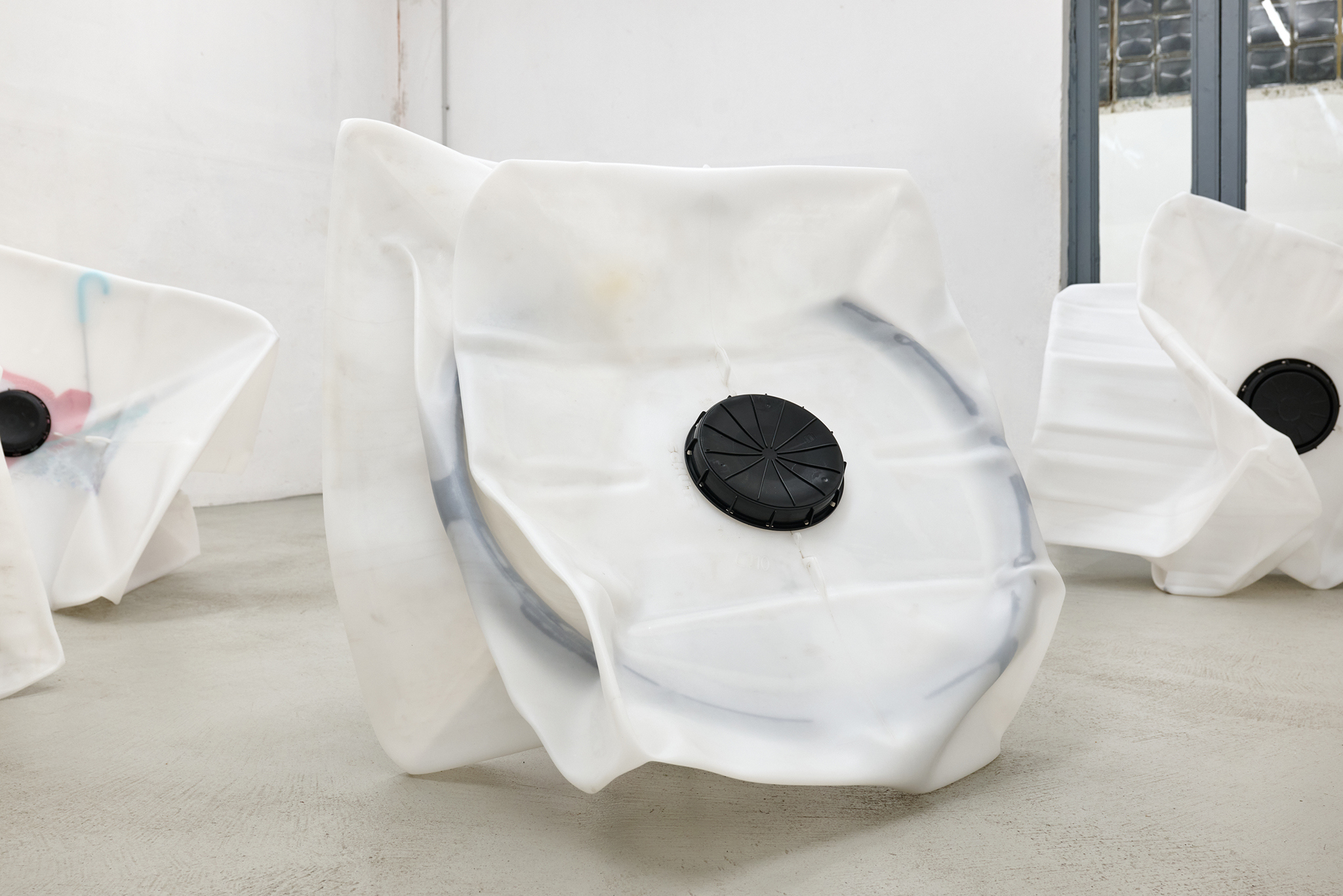 Sacha Kanah, Coccolino, 2025, IBC, valve, iron ring, vaseline, candy paper, vacuum, 88 x 107 x 117 cm