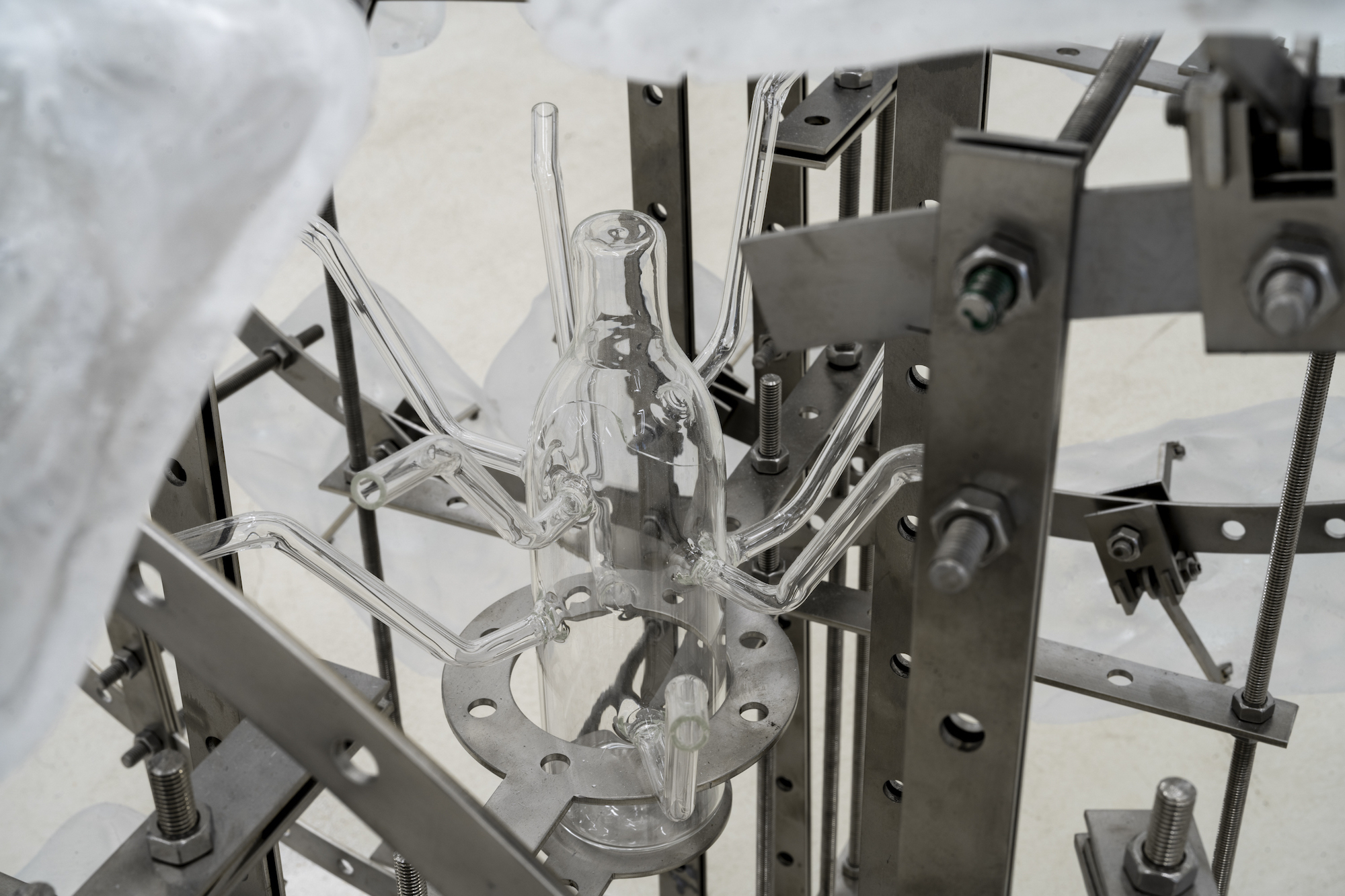 shy but ok (like being thirsty), 2024, stainless steel, epoxy, mutant glass bottle, white sand