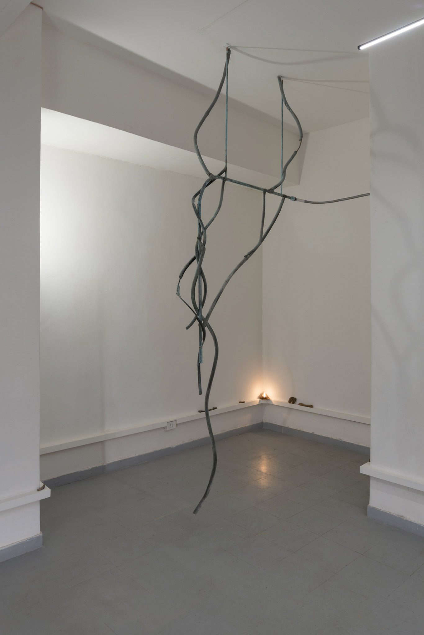 Andrea Mauti, Esausta (voices, voices), 2025. Copper, ashes from the firing of the clay objects displayed in the exhibition, gypsum, iron oxide, soil from the Caffarella Park, charcoal, customized fennel essential oil, steam, steel. 150 x 295 x 56 cm.