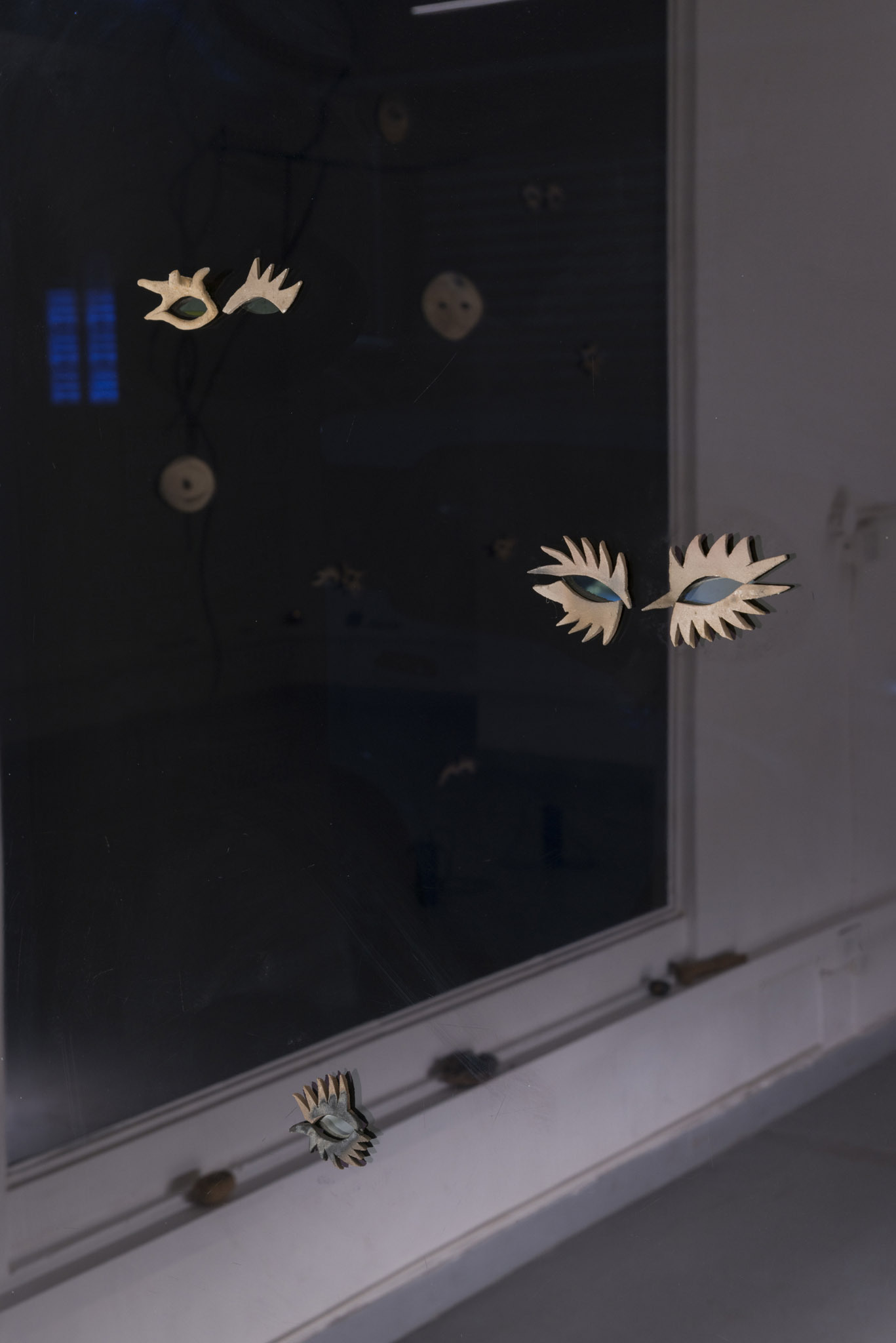 Ilare, Sbirciatine, 2025. Soil from Caffarella Park, sand from Ostia, recycled clay (black, red, white). Installation on windows, dimensions Variable.
