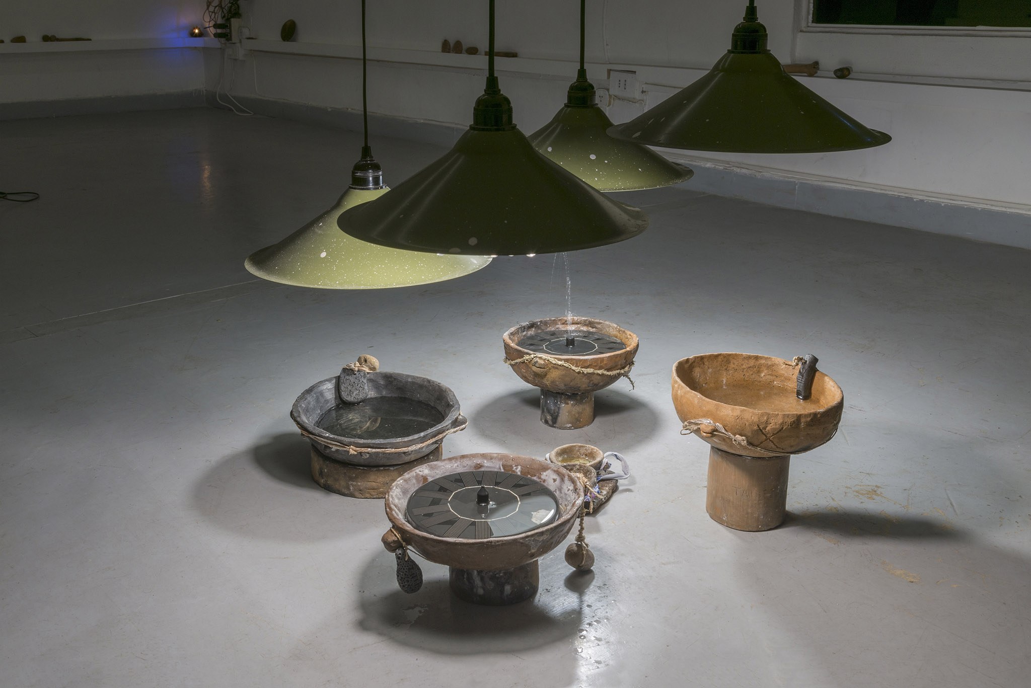 Clovis Maillet, MM, 2025. Soil from the Caffarella Park, vegetal wax, pieces of clothes from a victim of femicide, plants, water from the Loire River, holy water, solar fountains. 80 x 80 x 25 cm.