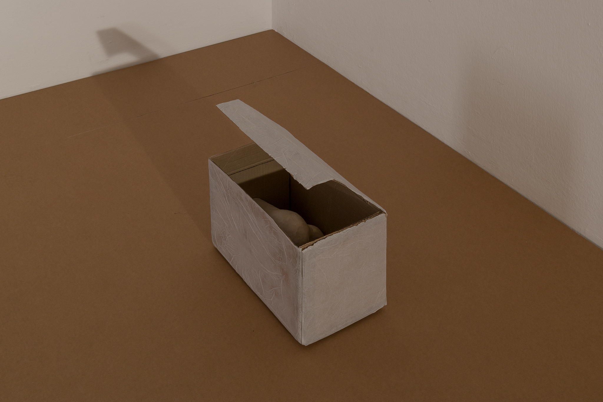 Breather, 2025. Plaster, tissue paper on cardboard box, office clip. 39 x 34 x 19 cm