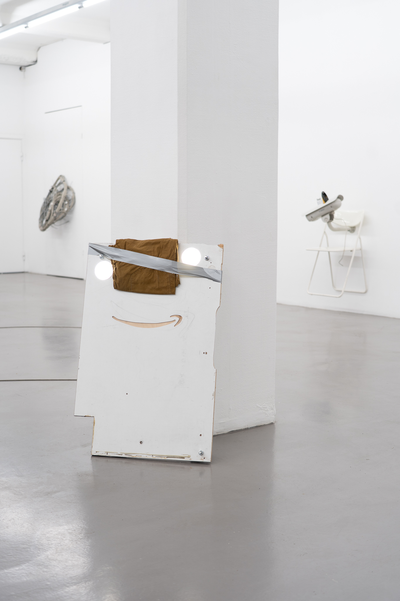 Nicola Arthen - Reading A Reflection (2025); Collage from generated images, machine-knitted wool, cotton and filling yarn, steel rig, C-prints, wooden carts with engravings, work pants, lights, sensors (760x160x145cm), courtesy of the artist and Platform