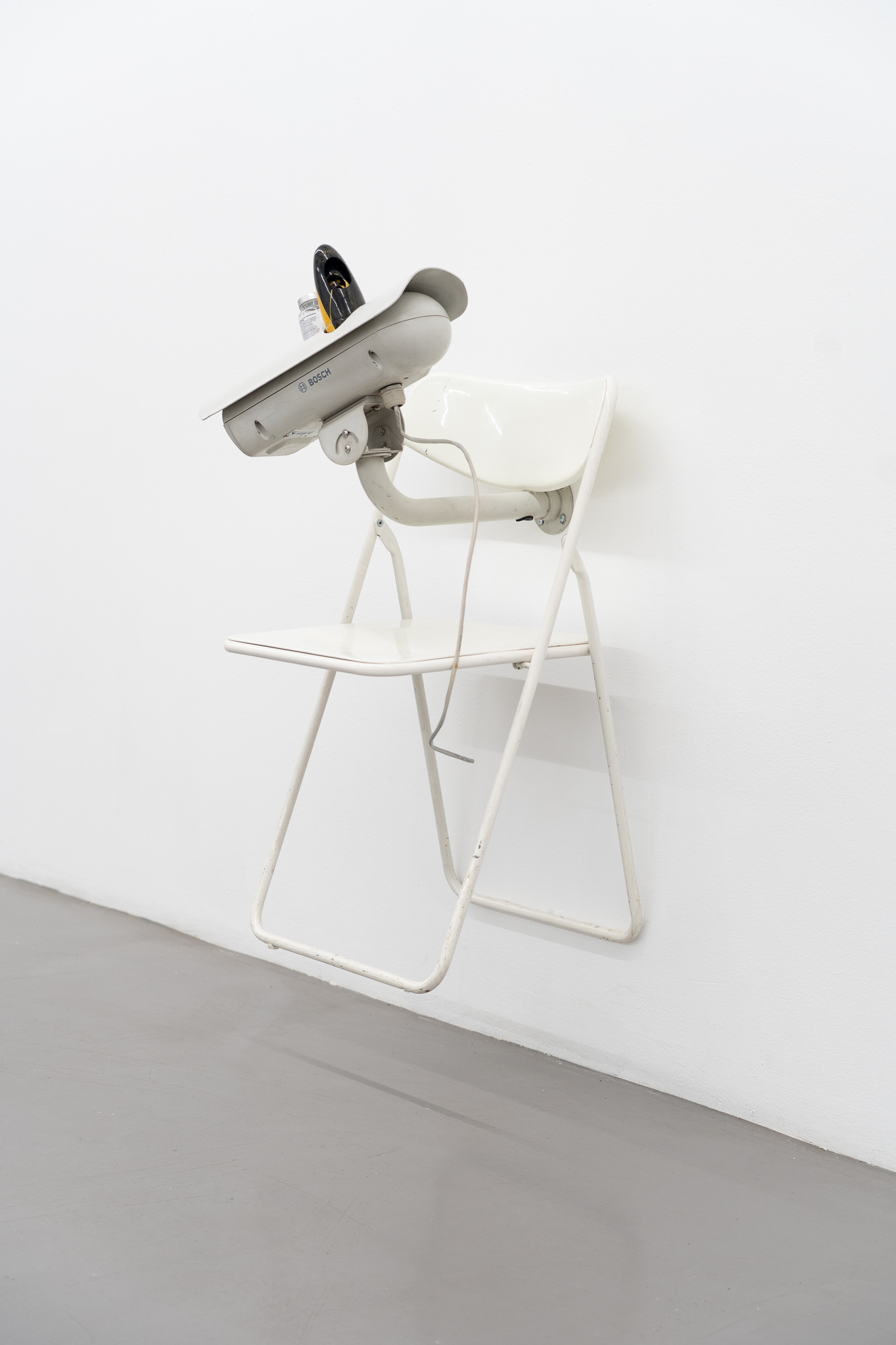 Rodrigo Red Sandoval - Self-conscious (2025); Bosch camera, foldable chair, self-contained wooden penguin, Magnesium pills (55x80x55cm), courtesy of the artist and Platform