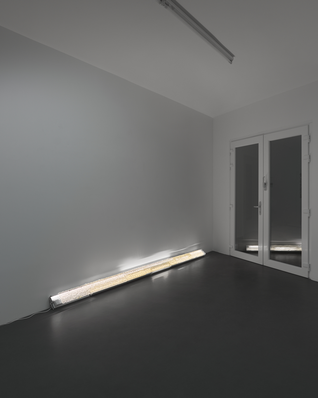 EWAESST, 2025, melted cupping glass, PVC window frame, light, 14x366x10 cm