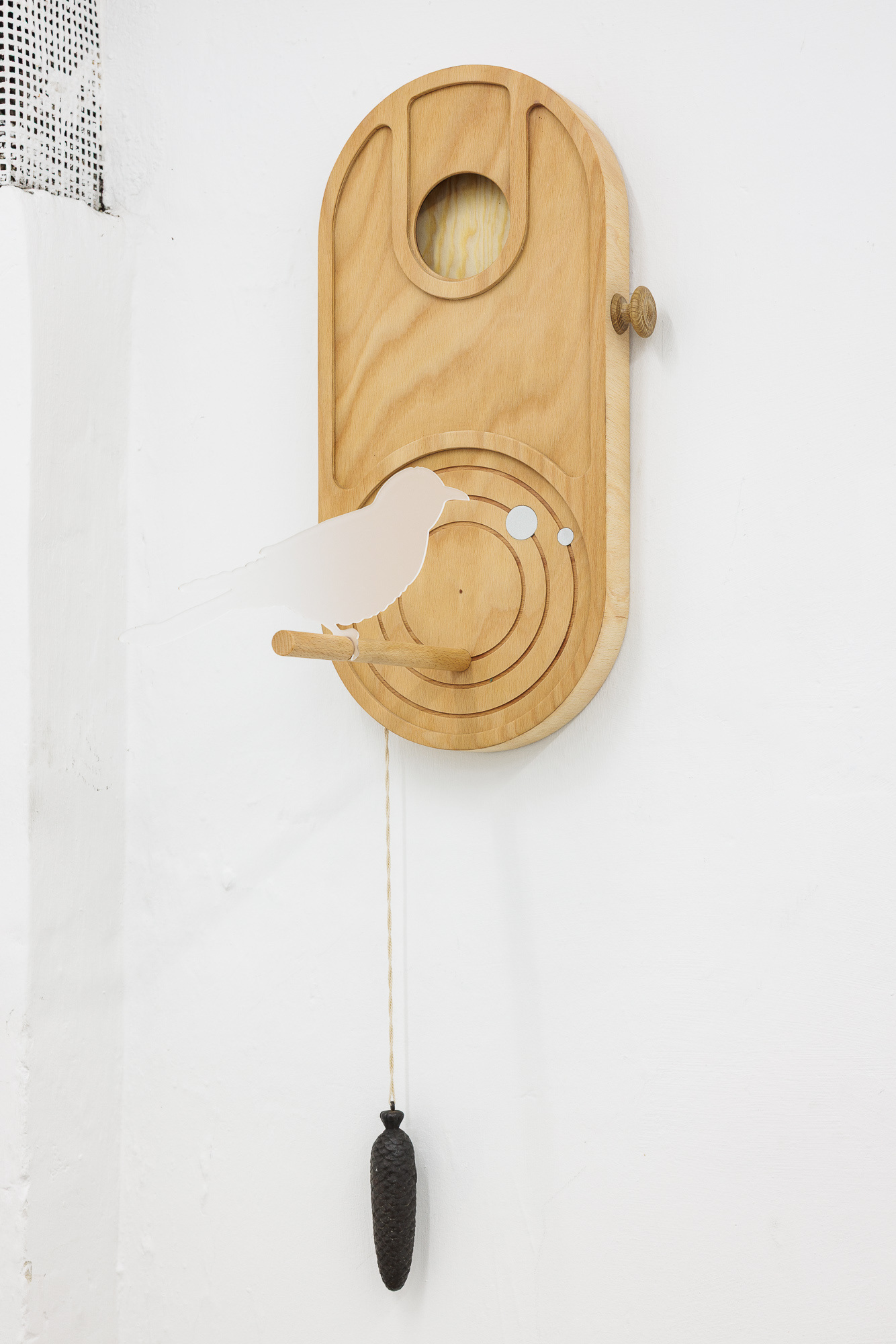 image: work / title and year: a memory, 2025 / material: ceiba and beech plywood, aluminium, acrylic glass, cotton rope, clock weight / dimensions: 60 x 27 x 21 cm
