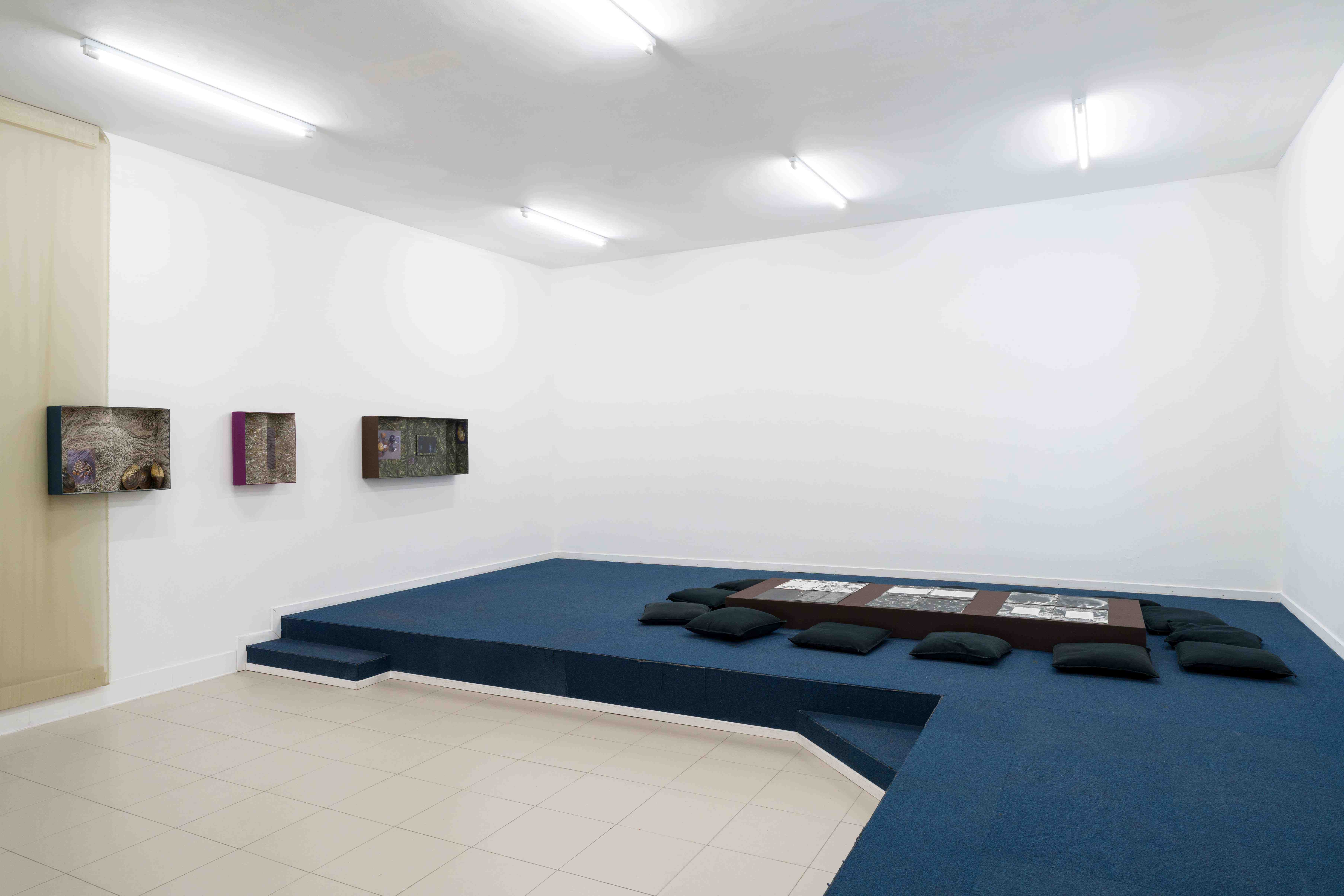  Milieux, 2025, Reading table, binding fabric, rings, glossary, and facsimile books, 90 x 245 x 18 cm. Élodie Lecat, trois, three, drie, 2025, Speaker, sound loop, 40 min. they built up the picture by Caroline Reveillaud. Image Lola Pertsowsky  