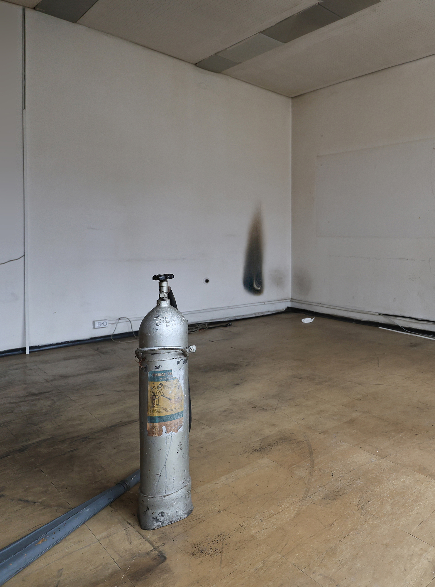 Andreea Anghel - Spatial intervention *beer bottles, tissues, plastic cups, bronze hunting dog statuette (with rabbit), burn stain, antique fire extinguisher⎼ etched text on the extinguisher reads: PUSTA (EMPTY)