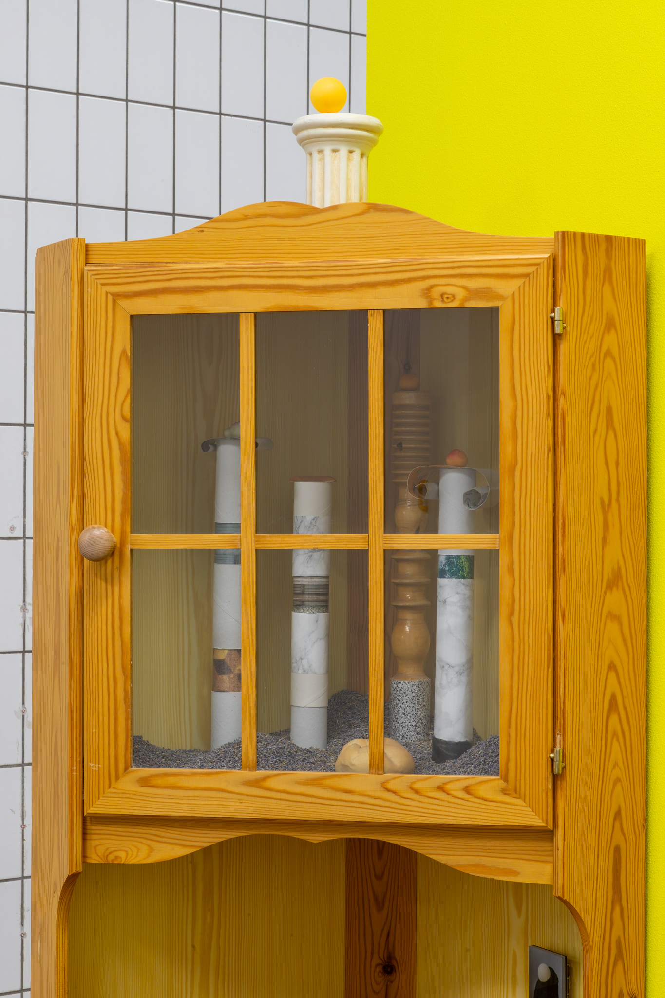 Hertta Kiiski & Janne Punkari: Bird´s House, 2025/2026, cabinet, lavender, wood, cardboard, contact paper, marzipan fruits, pigment prints, ceramic column and baguette, Venetian bun, black pepper, ping-pong ball, Diasec, wooden bird, 177x76x36 cm