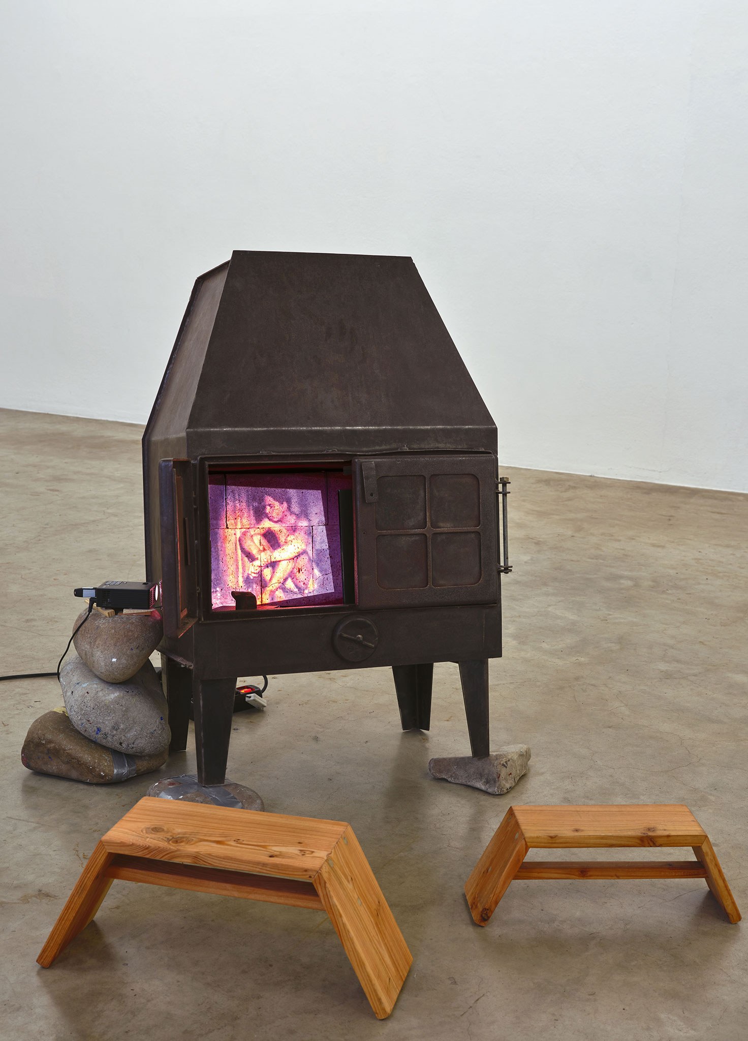 Béla Pablo Janssen , Ofen: Hermes – Keine Zeit Für Eile, 2011 – 2026, Edelstahl, 110 x 70 x 50 cm, Audiokassetten Loop, Super8 Film digital Loop 3 min., Spiegel, Steine, Keile, NAK Neuer Aachener Kunstverein. Courtesy: the artist.