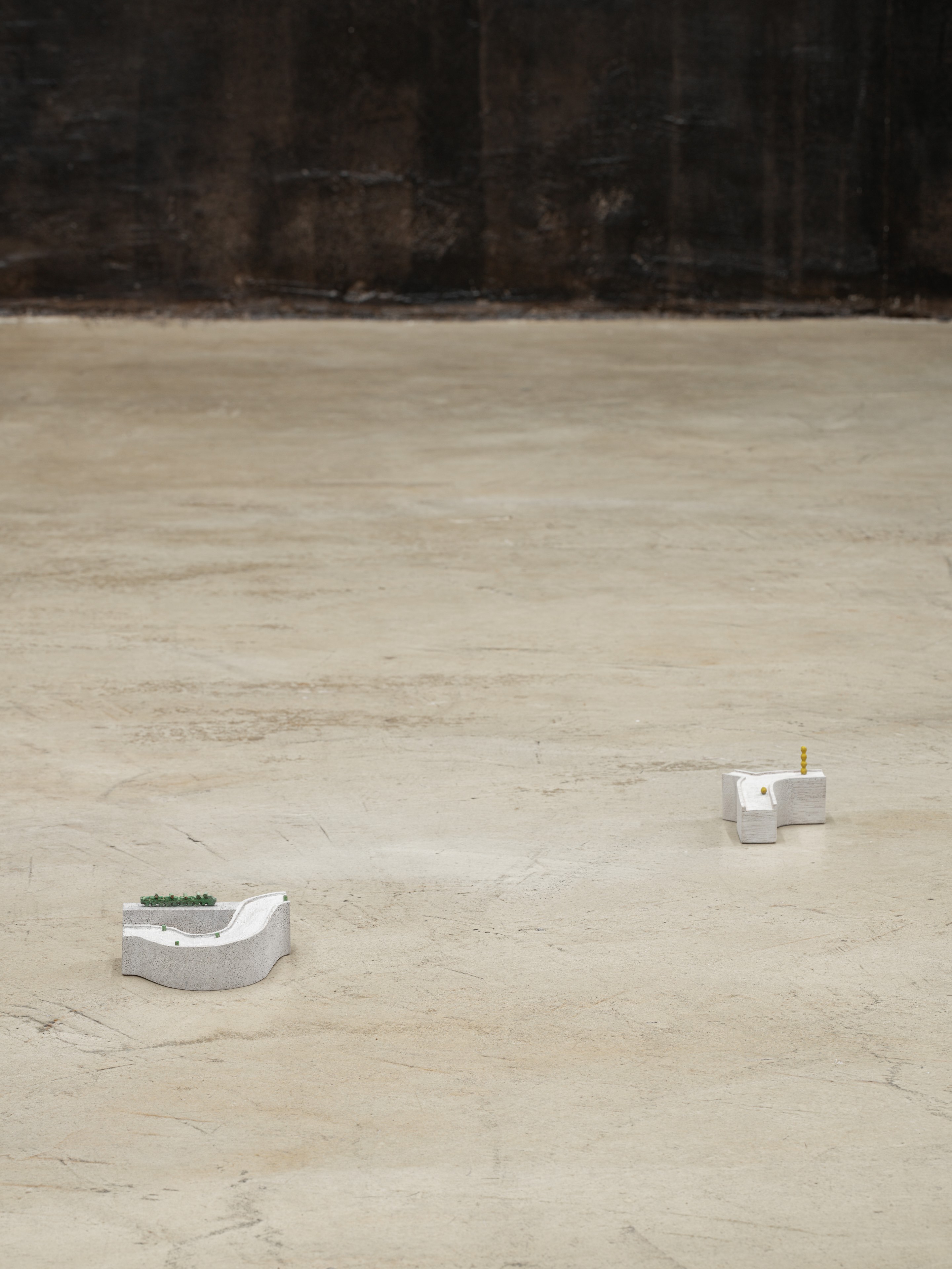 on the left: Kenji Ide, Sudden gust, 2026 Wood, water color, acrylic varnish, tape, 9 x 9 x 4 cm on the right: Kenji Ide, A strange feeling, 2026 Wood, water color, acrylic varnish, 7 x 8 x 5 cm