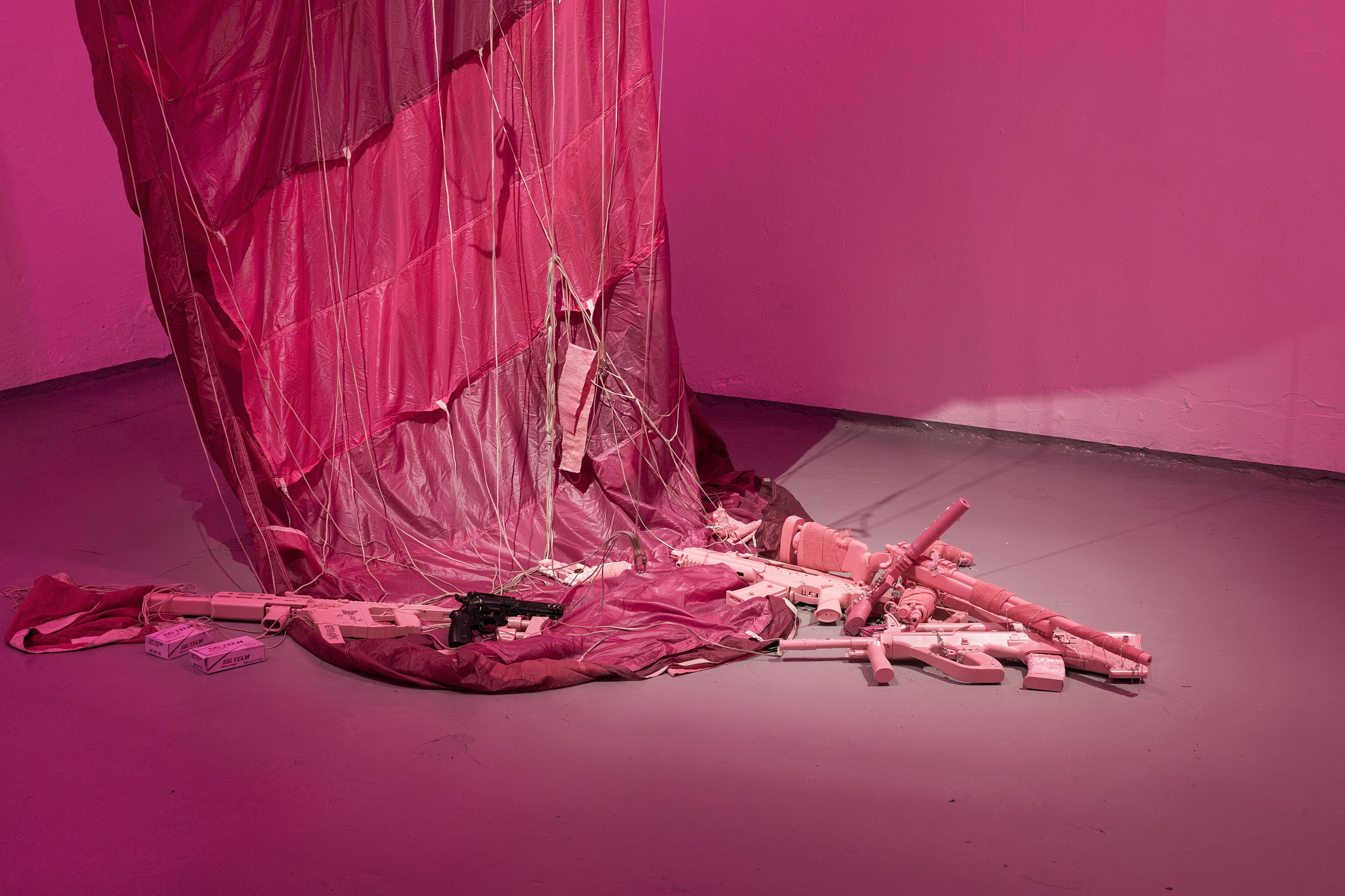 Keiu Maasik, Will I Die a Violent Death?, 2026. Spatial installation (plaster, metal, polyurethanene foam, ghillie suits, decorated 3D-printed weapon models and airsoft guns, redesigned cartridge boxes, used parachute canopy, video with sound). 