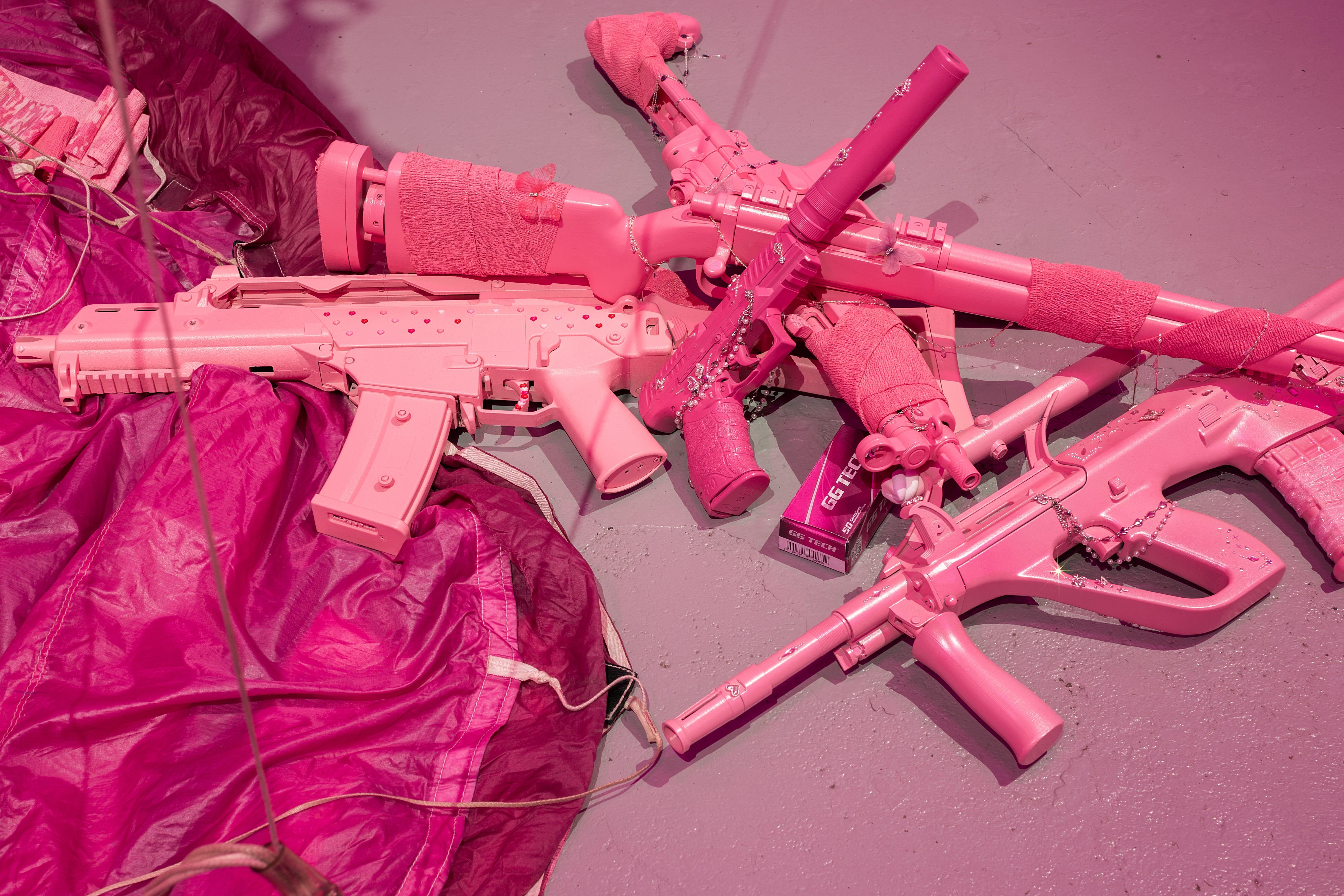 Keiu Maasik, Will I Die a Violent Death?, 2026. Spatial installation (plaster, metal, polyurethanene foam, ghillie suits, decorated 3D-printed weapon models and airsoft guns, redesigned cartridge boxes, used parachute canopy, video with sound). 