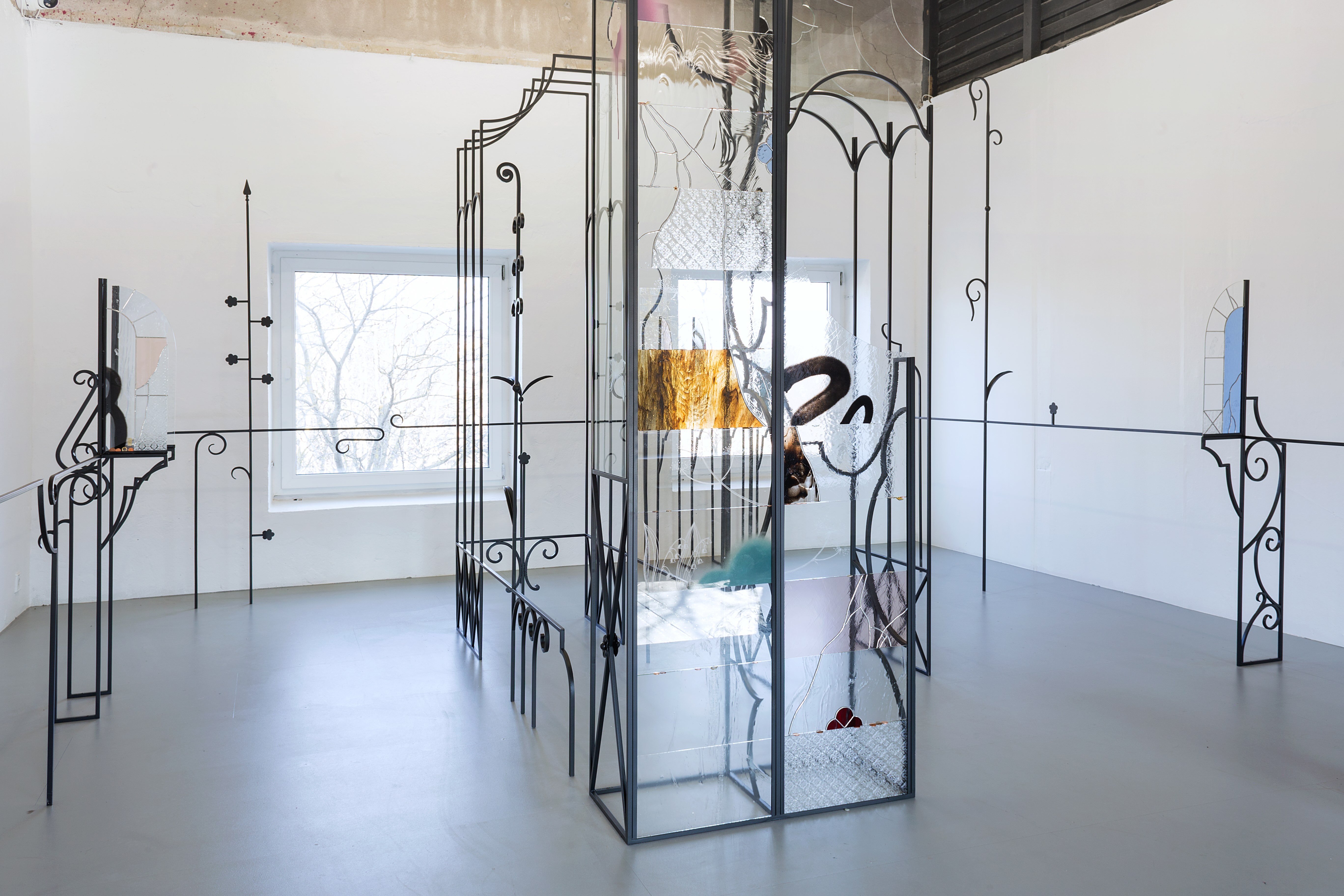 Anna Mari Liivrand, Amid Bitter Flowers, 2026. Installation (wrought iron, stained glass, antique glass, found glass, solder, spray paint, coins, buttons and ohter found objects).