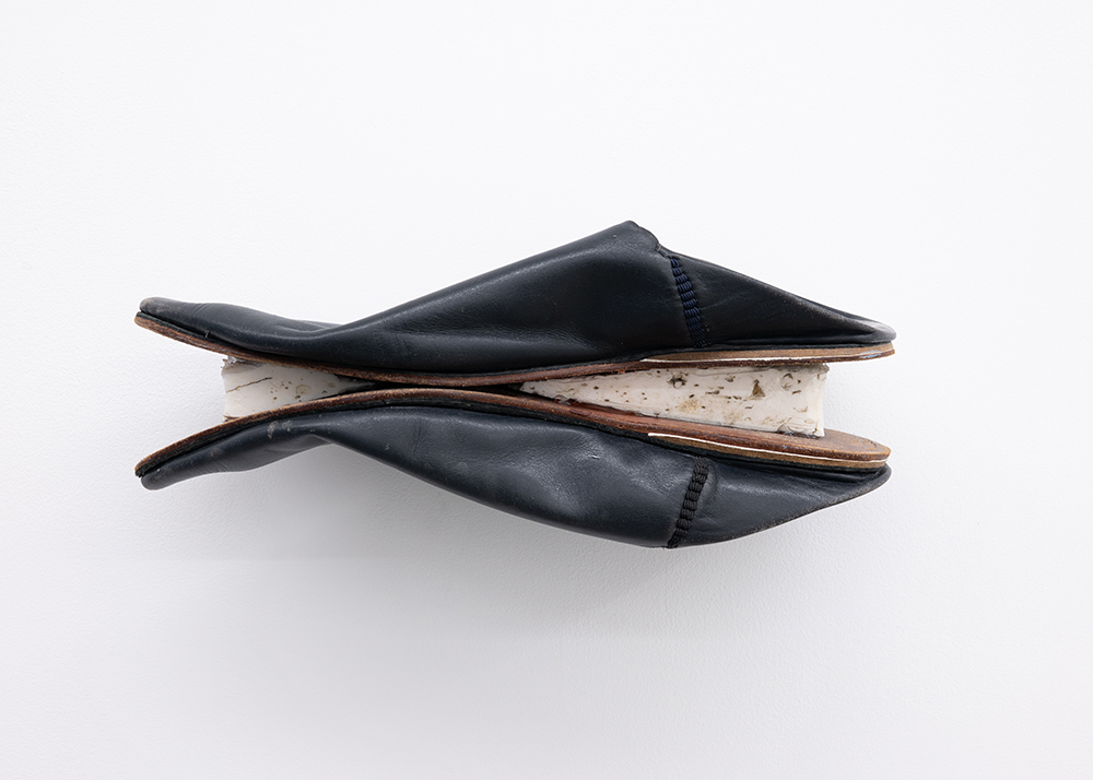 Adam Vit, untitled, 2026, leather slippers, polystyrene foam, metal, 12 x 29.5 x 10.5 cm