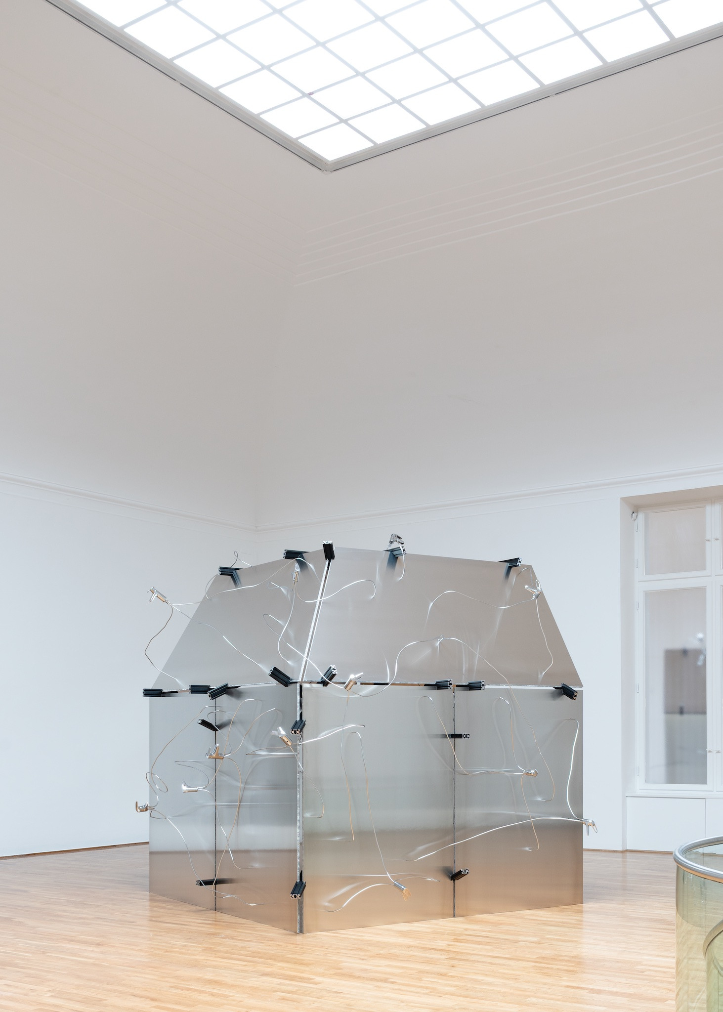 DER KÖRPER WEISS BEFORE THE GEIST 2026 aluminium panels, chrome-plated pipes, fittings, system profiles, 340 × 390 × 350 cm, Foto by Maximilian Geuter Copyrights the artist & VG Kunst, Bonn, Installation view FELD, Museum Villa Stuck