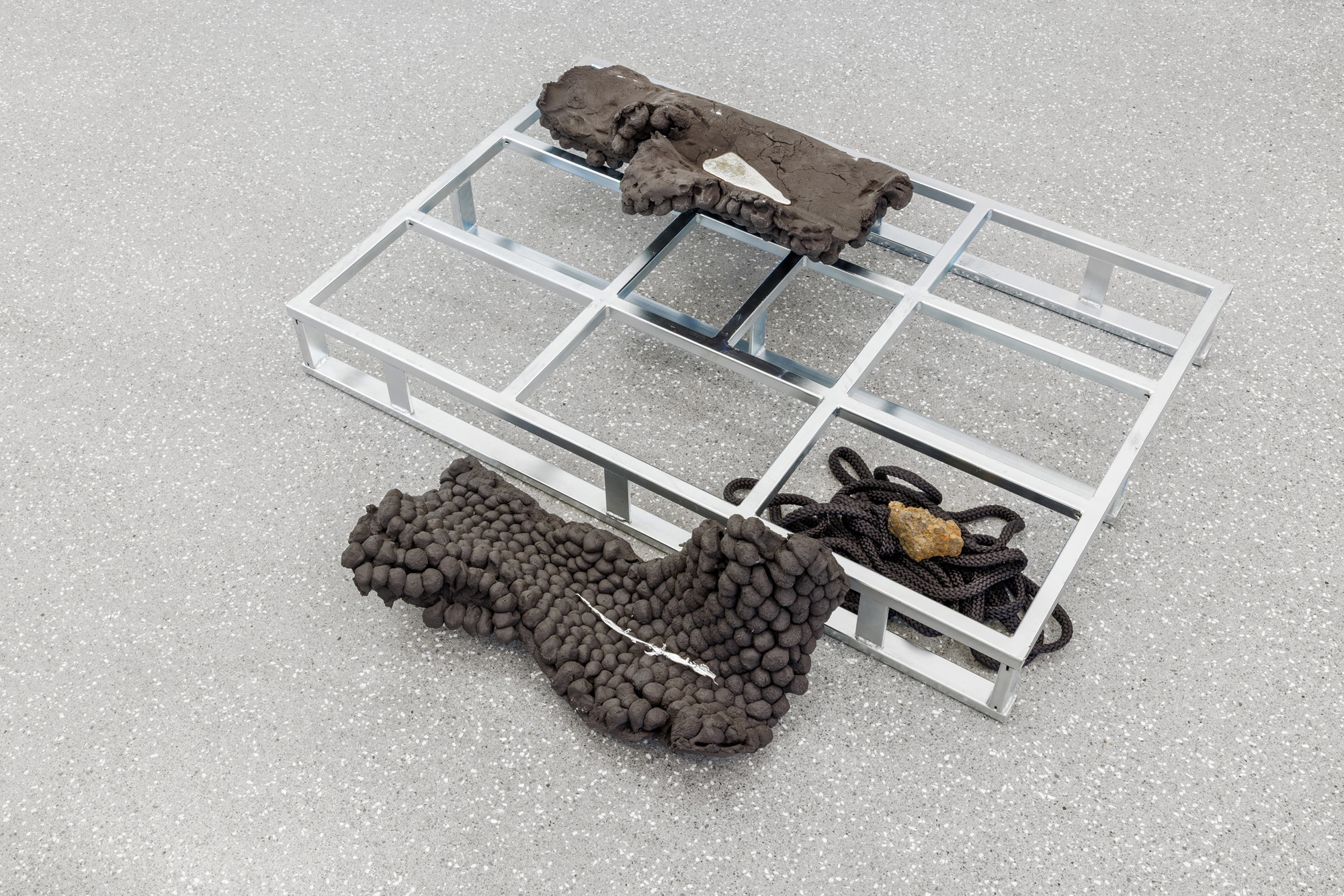Peles Duo, Iron Folds I, 2025 steel pallet, black grog ceramics, tin, rope and ca. 2000-year-old iron slag from Gerhardsseifen Archaeological Site 150 x 95 x 30 cm