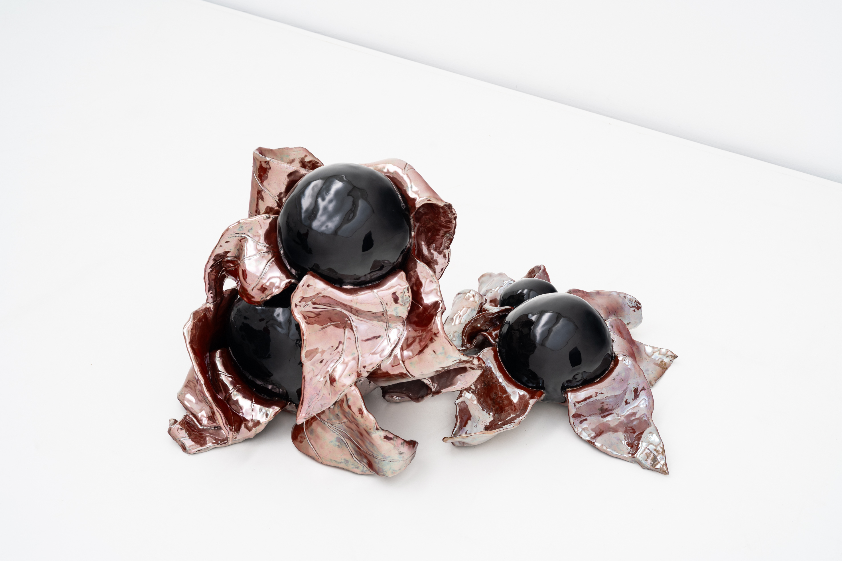  Installation view of Nightshade 4 (2021) and Berries 1 (2021), Kunstraum Remise, Bludenz, 2026. 40 x 60 x 46 cm and 16 x 50 x 40 cm. Glazed ceramic. Photo: Christa Engstler. Courtesy of Kunstraum Remise Bludenz and the artist.