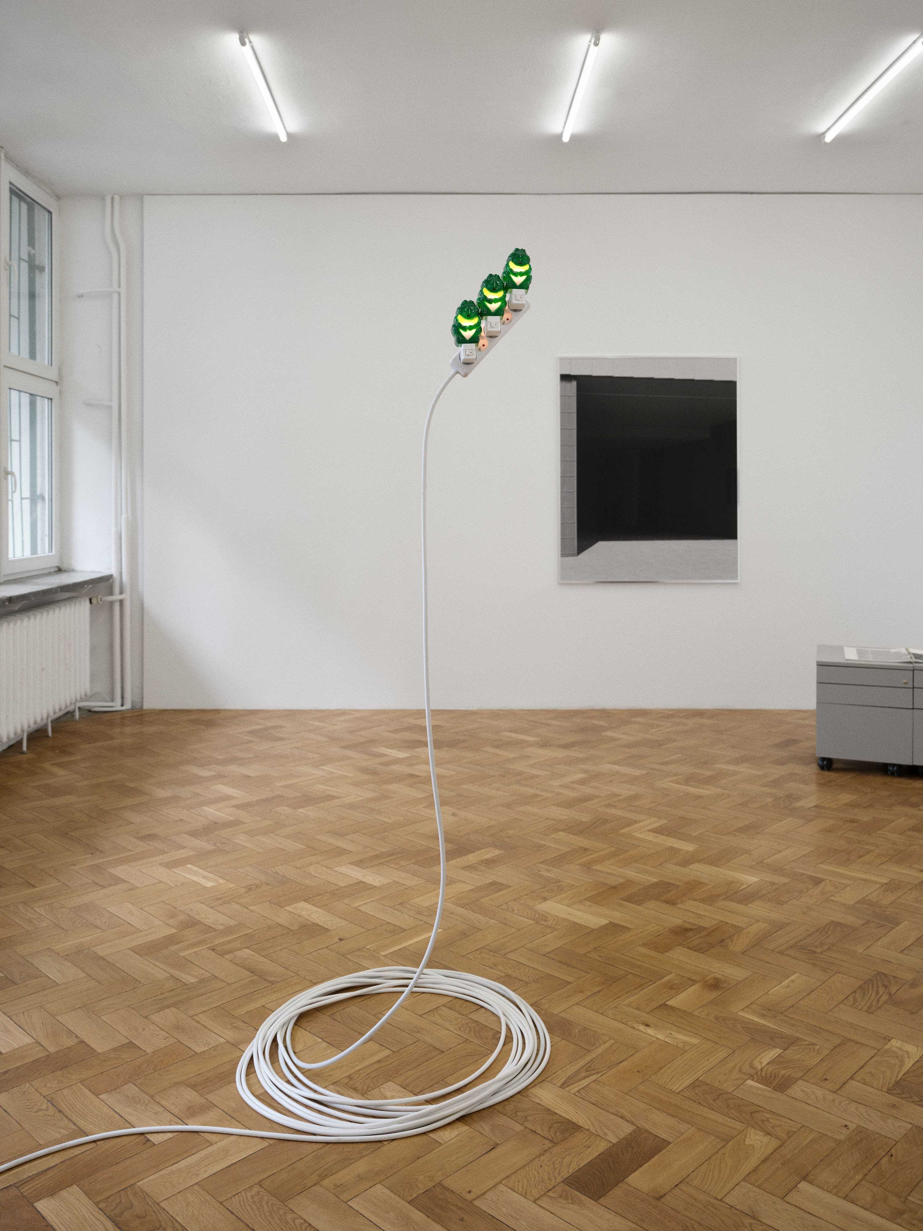 Piotrek Kowalski, _Triplets_, 2026, extension cord, stainless steel, plug-in lights, 190 × 80 × 80 cm